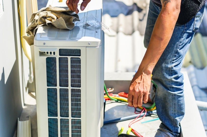 Utopia AC System Replacement - Technician replacing A/C Unit