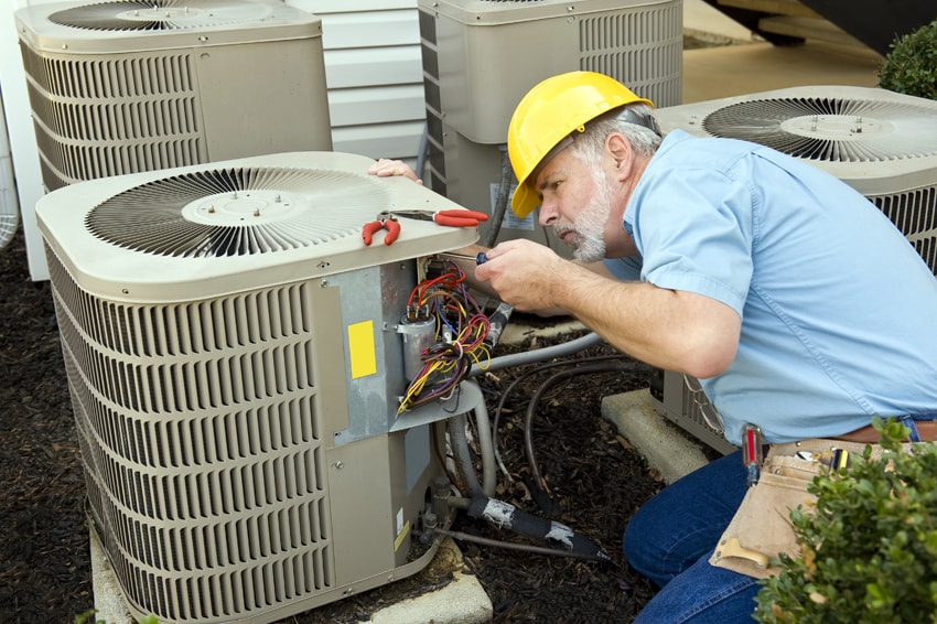 A/C Maintenance Utopia - Technician preforming maintenance on an air conditioner.